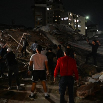 Personas de pie junto a un edificio derrumbado tras un terremoto en Caracas el 24 de junio de 2026.