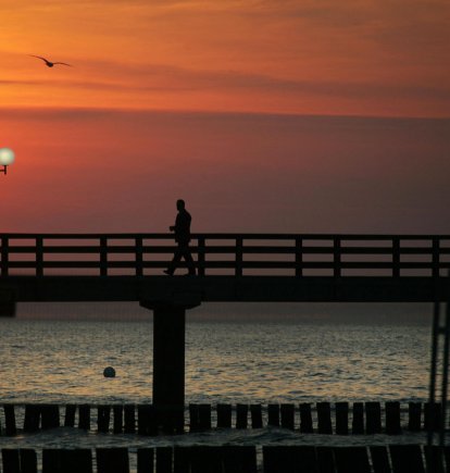 Un hombre solitario camina por un muelle