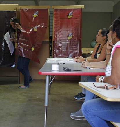 Una mujer sale de una cabina de votación después de emitir su voto durante el referéndum para el estatus político de Puerto Rico en un colegio electoral en Guaynabo, el 11 de junio de 2017.