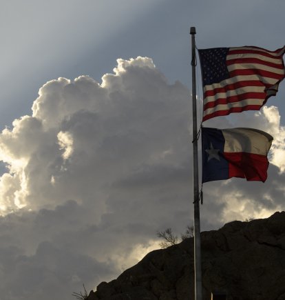 La bandera de los Estados Unidos y la bandera del estado de Texas se exhiben en el parque Murchison Rogers a lo largo de Scenic Drive al atardecer el 24 de junio de 2021 en El Paso, Texas.
