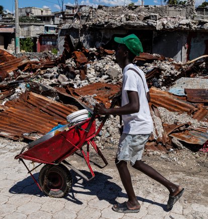 Un comerciante camina alrededor de casas destruidas por bandas armadas en un barrio de Haití