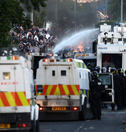 La policía utiliza un cañón de agua mientras bloquea el paso a los manifestantes en Glengormley, al norte de Belfast