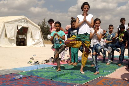 Reference image of the tree pose showing a woman in the company of children.