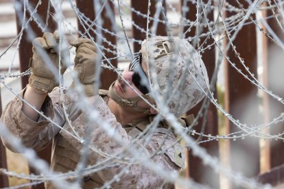 Un marine sujeta concertina a lo largo del muro cerca de San Ysidro, California