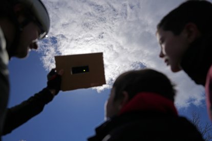 Una familia observa el eclipse solar parcial desde Burgos (España)