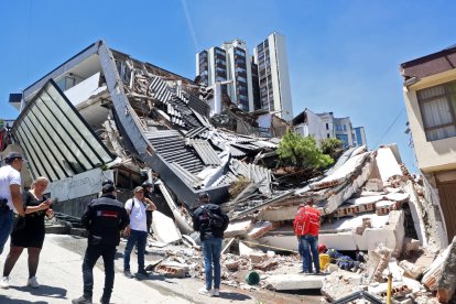 People remain near a collapsed building after an earthquake in Manizales, Colombia