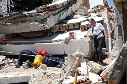 Rescuers search for survivors at a collapsed building after an earthquake in Manizales, Colombia