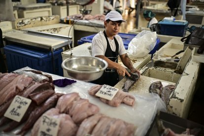A fishmonger cleans a fish at the seafood market in Panama City