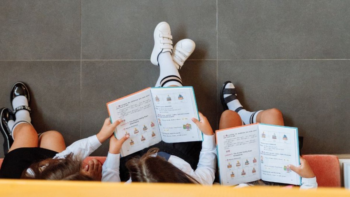 Varios niños leen un libro en la escuela.