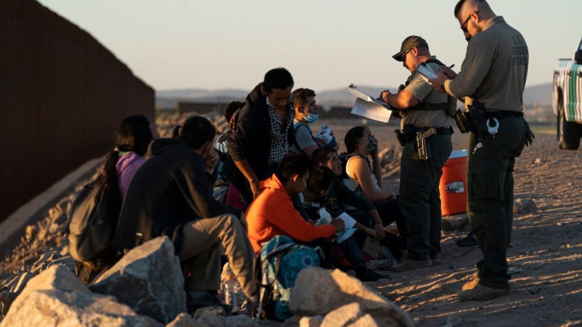Agentes de la CBP junto a un grupo de inmigrantes en la frontera.