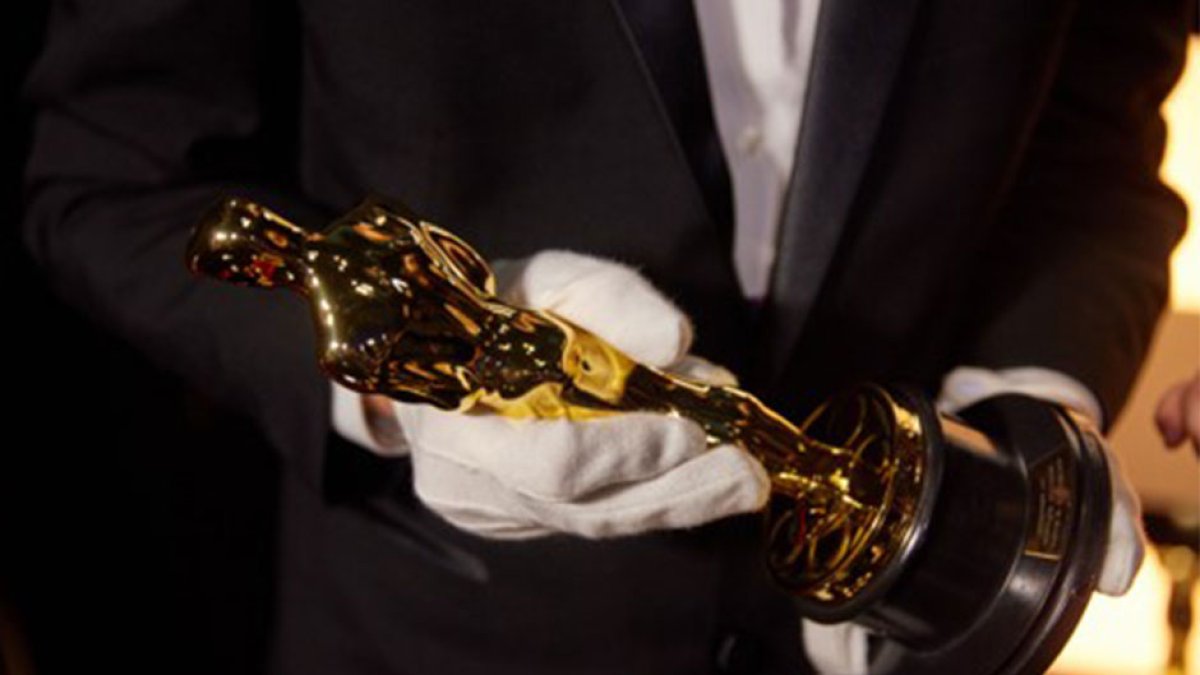 One of the Oscars Awards being held by the man in charge of custoding them