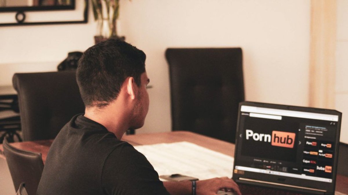 Joven consultando el sitio web de contenido para adultos Pornhub.