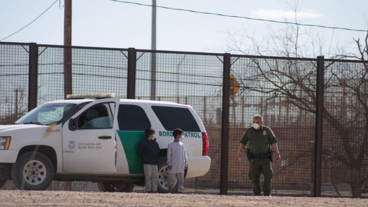 Two immigrant children surrendered to a border patrol agent after crossing the Rio Grande