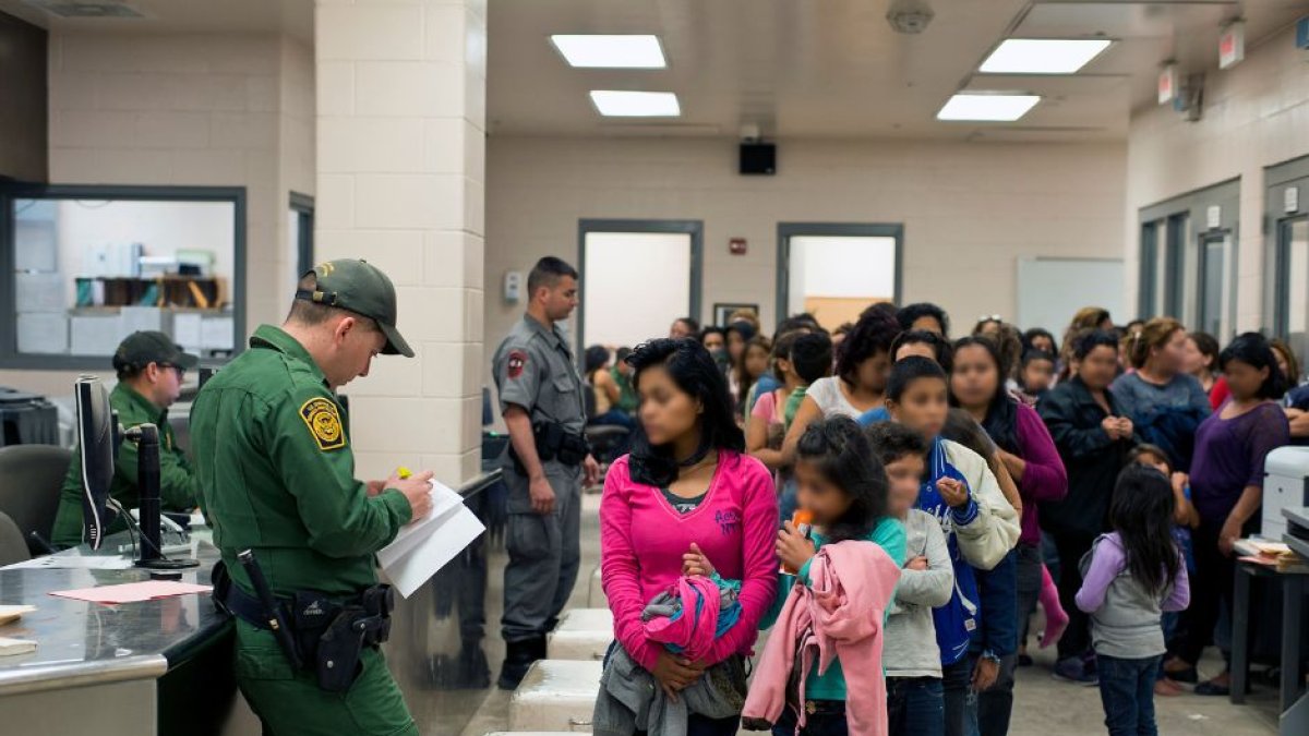 Several immigrants are assisted by members of the Border Patrol to enter the country.