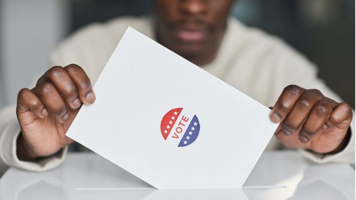 Un votante negro deposita su papeleta.