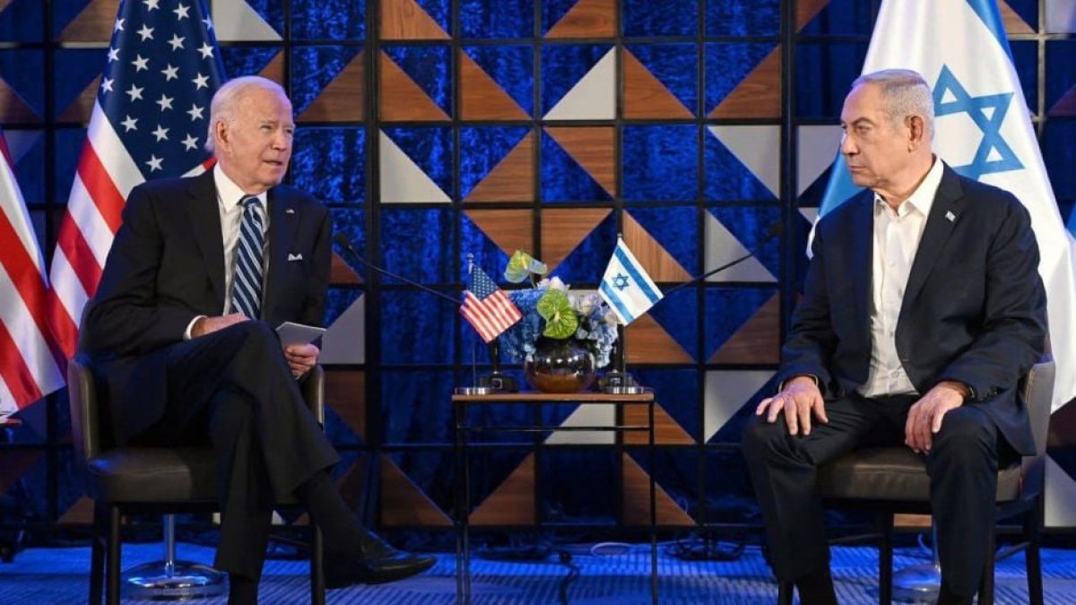 El presidente Joe Biden sentado junto al primer ministro israelí Benjamin Netanyahu el 18 de octubre. Detrás y al costado, banderas de los países que encabezan.