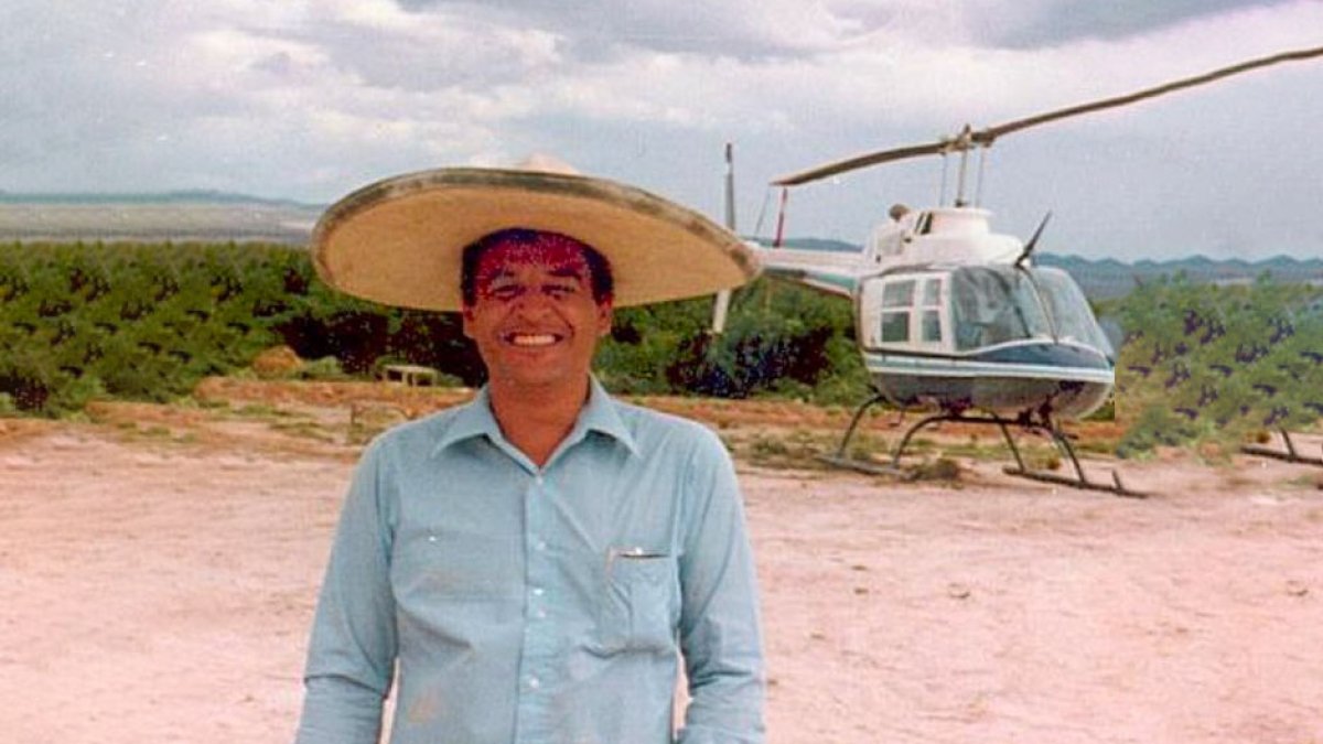 Fotografía de archivo de Kiki Camarena, vistiendo un sombrero mexicano y posando delante de un helicóptero.