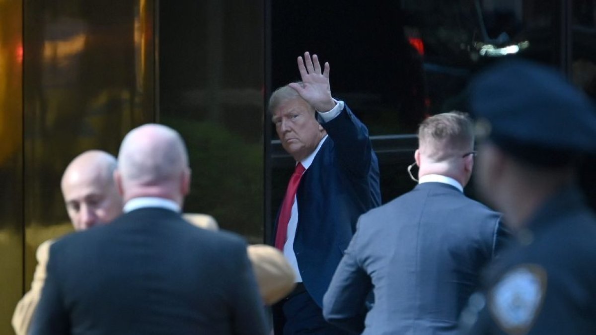 Trump saluda a su llegada a la Torre que lleva su nombre en Nueva York.