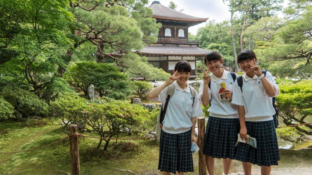 Tres alumnas frente a una escuela en Japón.