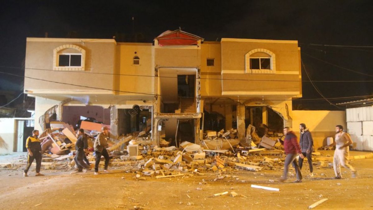 Palestinos inspeccionan las ruinas de una casa tras un ataque aéreo israelí antes del amanecer del 9 de mayo de 2023.