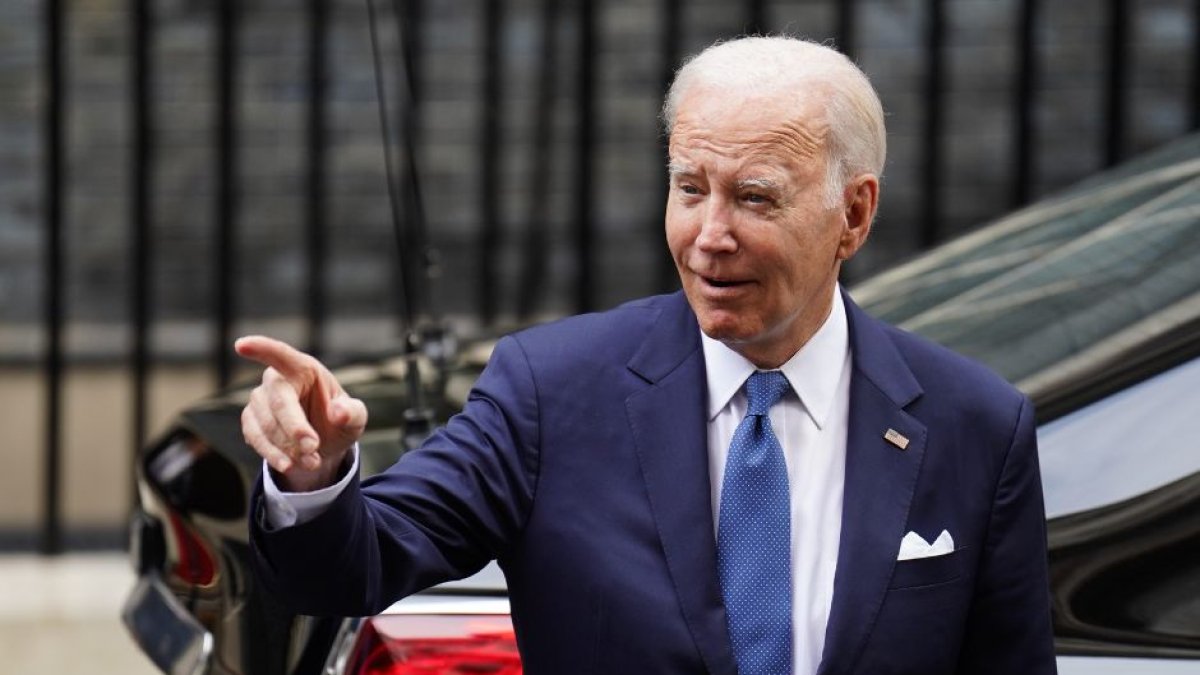 El presidente Joe Biden señala un coche mientras camina.