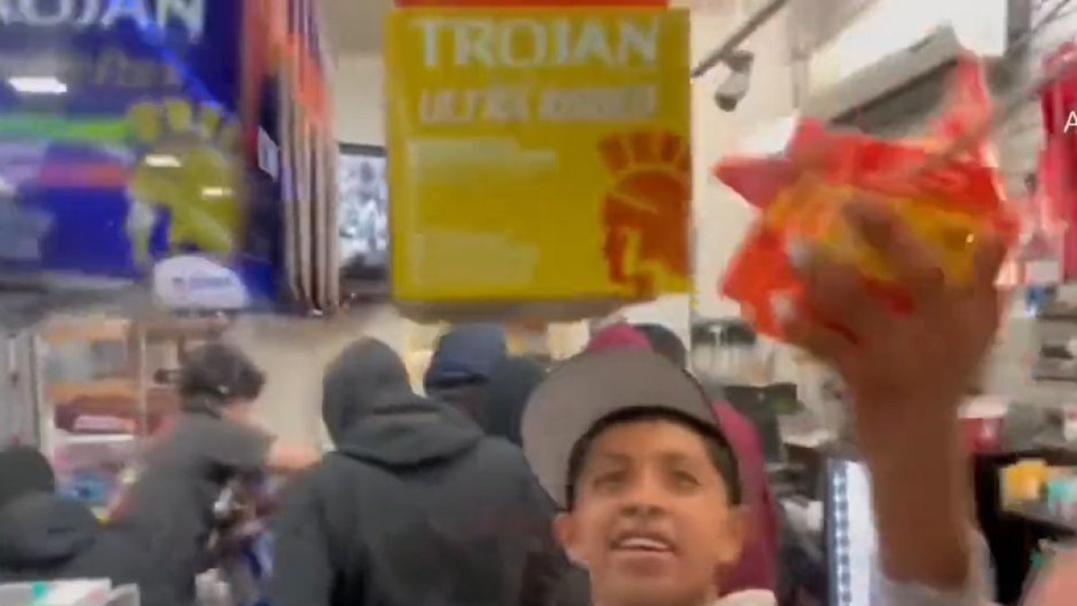 Momento del vídeo en el que se muestra como un joven roba paquetes de preservativos de la gasolinera asaltada.
