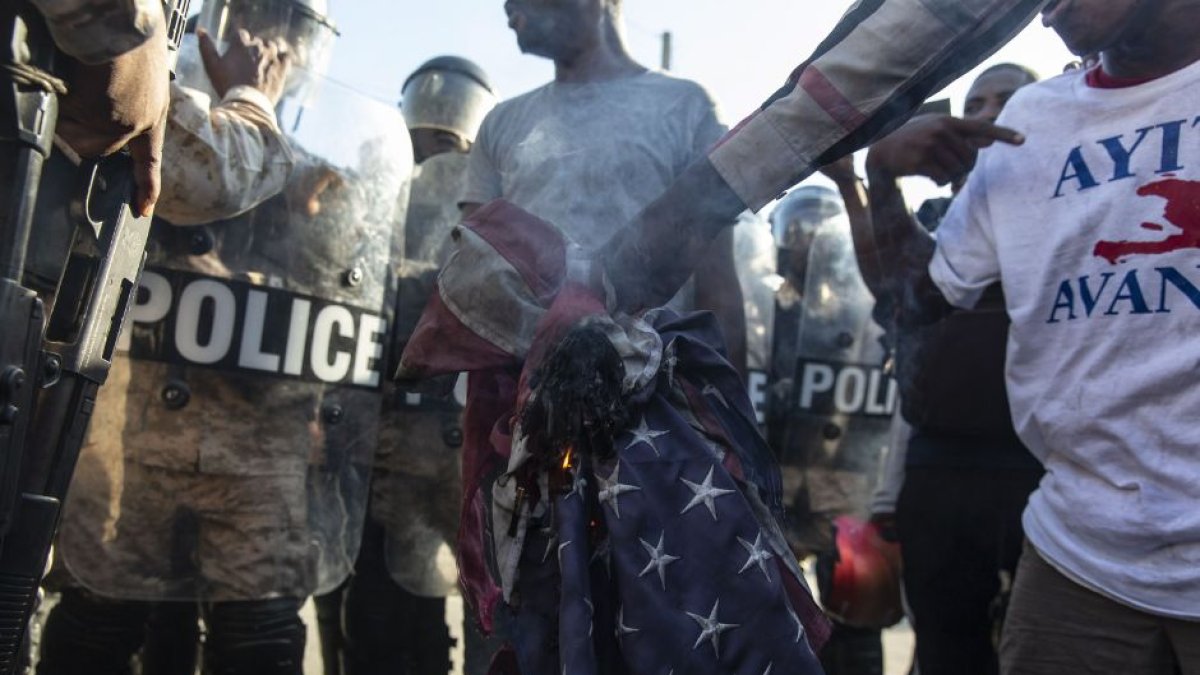 Une bandera de Estados Unidos arde durante una manifestación violenta en Haití.