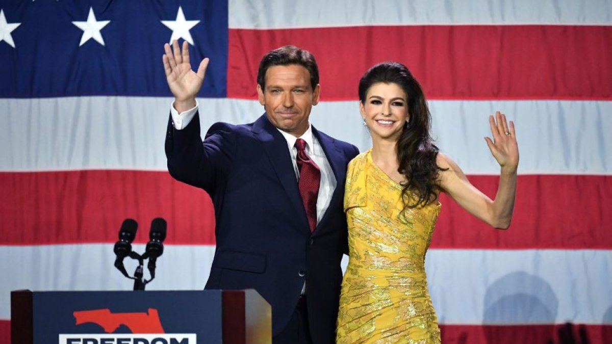 Ron DeSantis junto a su mujer en un atril frente a la bandera Norteamericana.