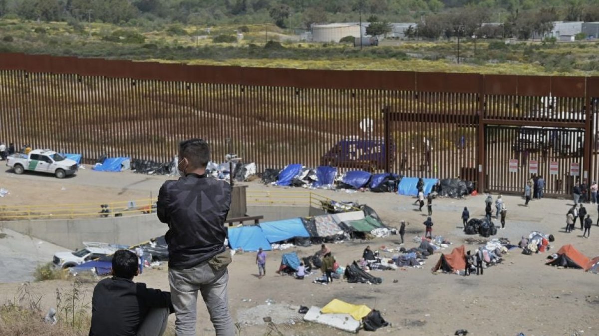 Migrantes frente a una valla en la frontera sur.