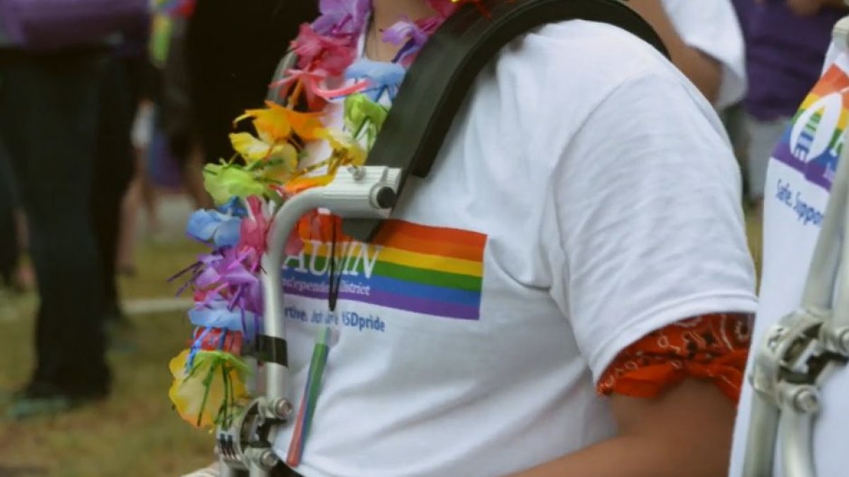 Estudiante vistiendo una remera del Distrito Escolar Independiente de Austin con los colores de la bandera LGBT en una edición pasada del desfile del Orgullo (Vimeo: AISD.TV).