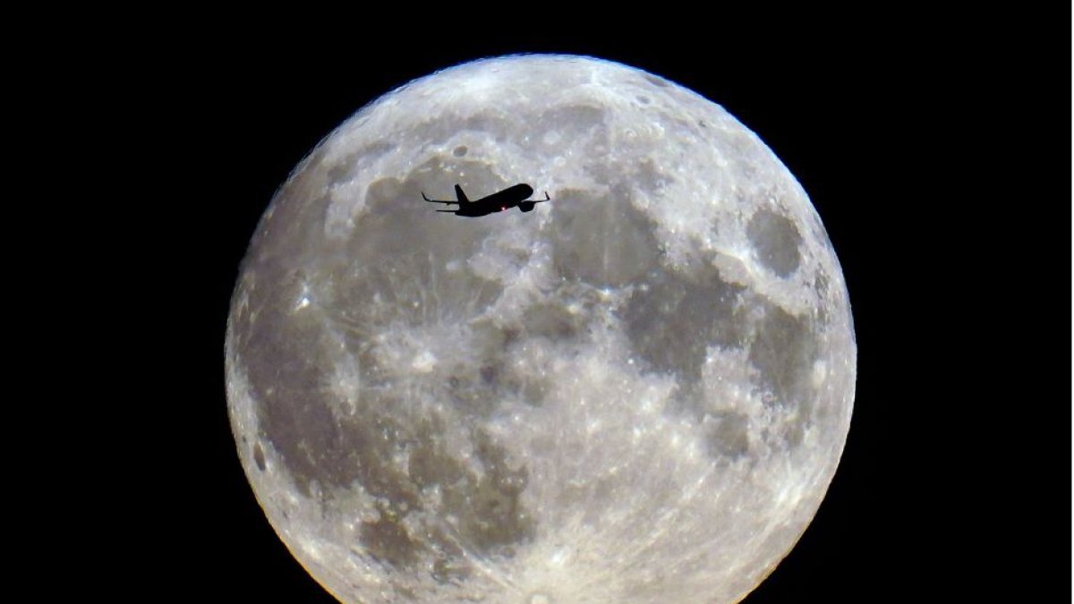 Un avión sobrevuela Londres en medio de la superluna azul