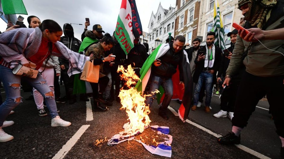 Manifestantes pro-palestina queman la bandera de Israel en una protesta en Londres, en una imagen de archivo.