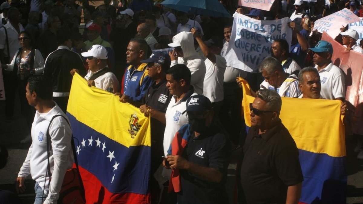 Venezolanos protestando en la calle con banderas del país en 2023.