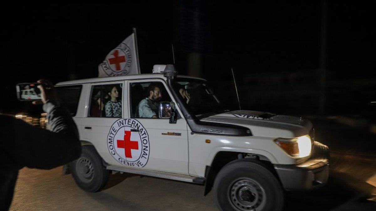 Miembros del personal de la Cruz Roja trasladan a rehenes liberados al paso fronterizo de Rafah, en el sur de la Franja de Gaza, el 25 de noviembre de 2023.