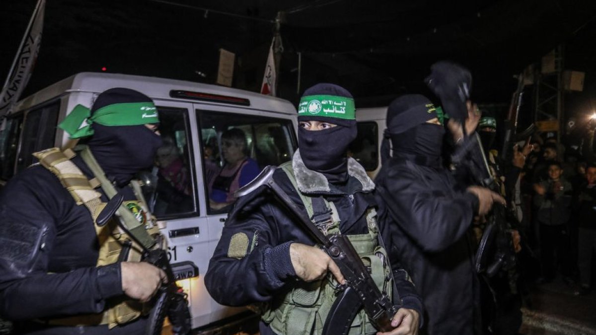Hamas fighters handing over hostages to the Red Cross.
