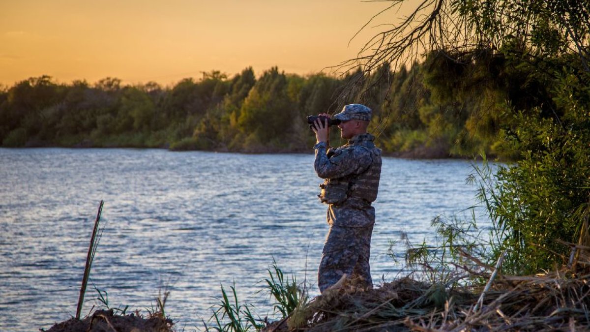 Un soldado de la Guardia Nacional de Texas patrulla el Río Grande, entre México y Estados Unidos, al atardecer.