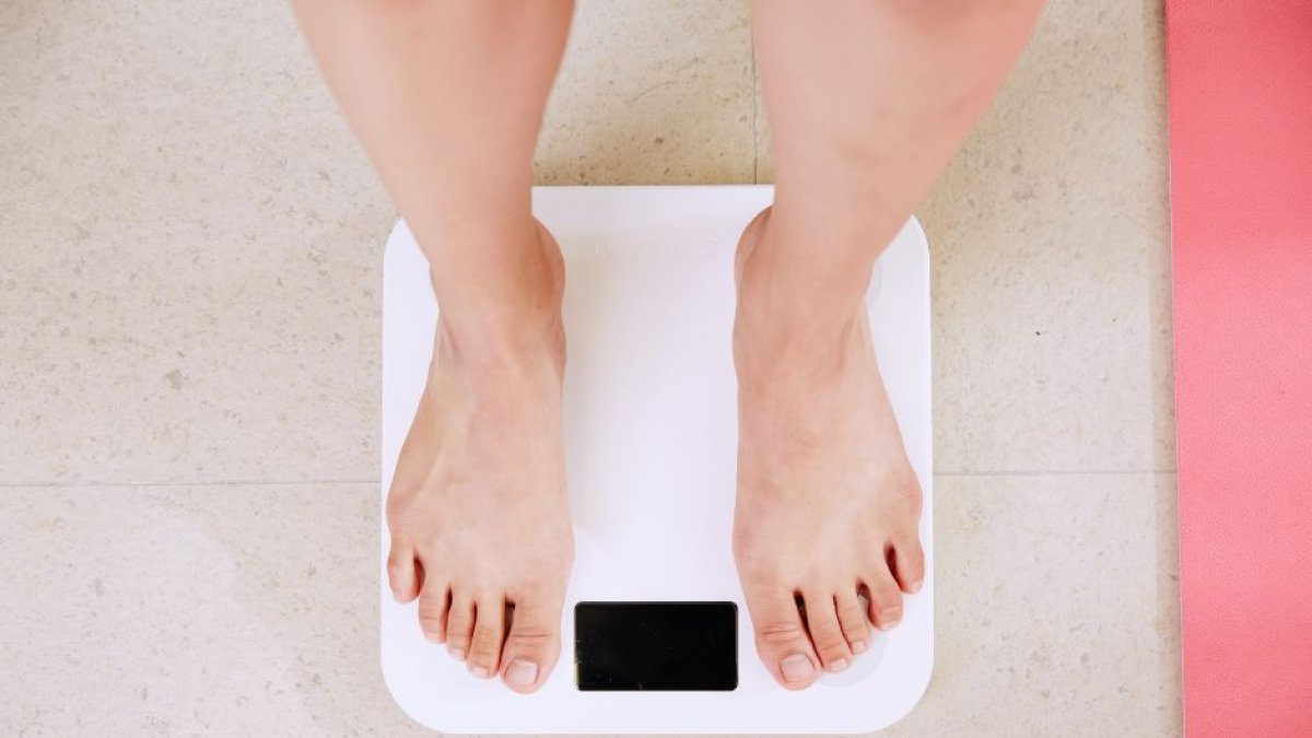 Persona pesándose para controlar su peso.