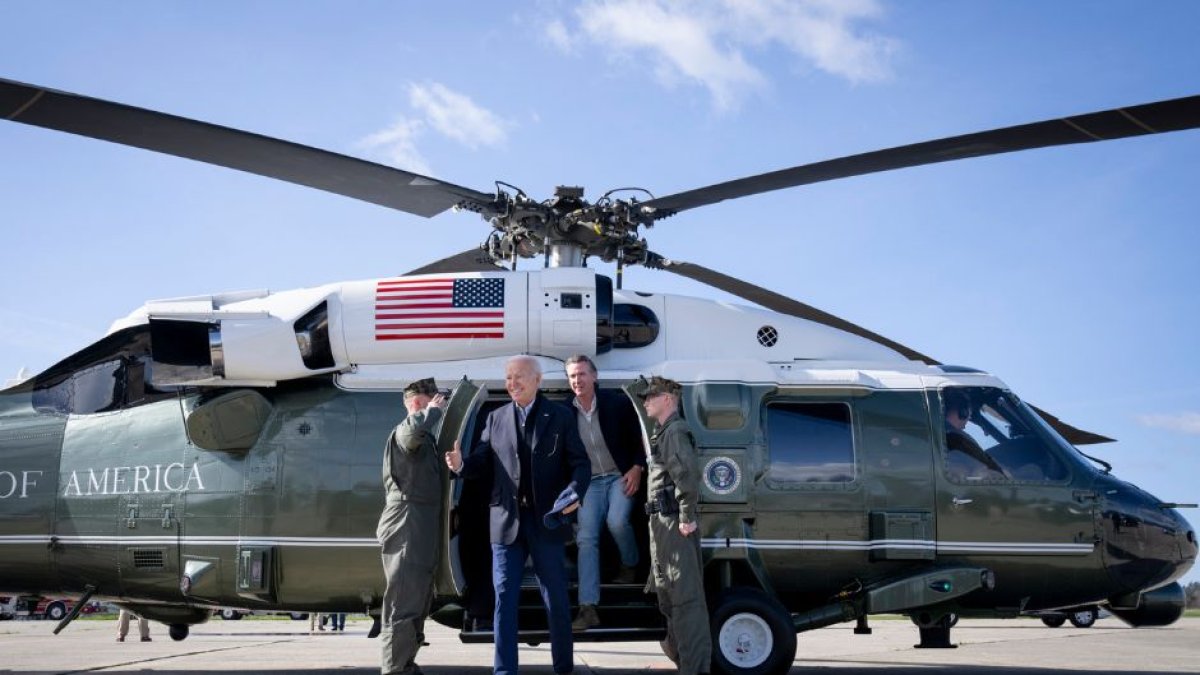 Joe Biden y Gavin Newsom descienden de un helicóptero.