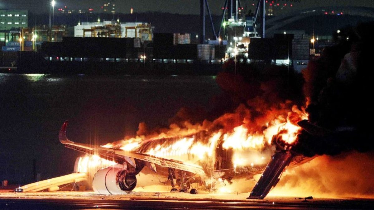 This photo provided by Jiji Press shows a Japan Airlines plane on fire on a runway of Tokyo's Haneda Airport on January 2, 2024. A Japan Airlines plane was in flames on the runway of Tokyo's Haneda Airport on January 2 after apparently colliding with a coast guard aircraft, television reports said.