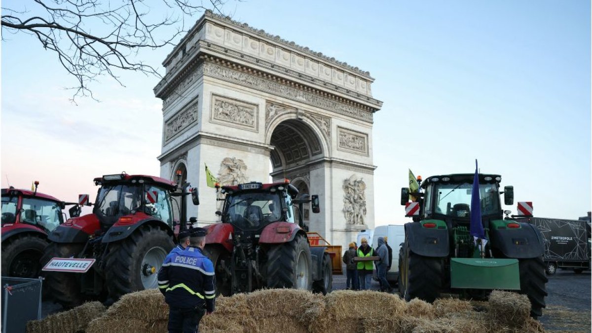 Policías observan tractores aparcados junto al Arco del Triunfo en la avenida de los Campos Elíseos durante una protesta del sindicato de agricultores franceses en París el 1 de marzo de 2024.