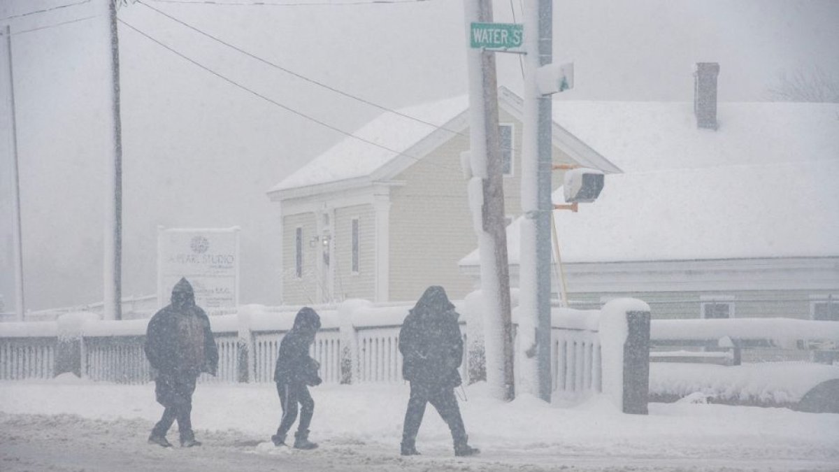 Gente caminando en plena nevada en Lawrence, Massachusetts el 7 de enero de 2024 durante la tormenta invernal masiva.