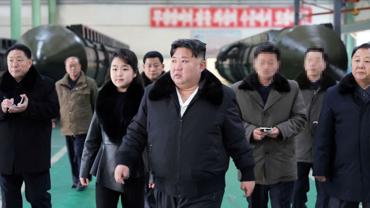 Imagen difundida por la Agencia Central de Noticias de Corea del Norte (KCNA) el 5 de enero de 2024 que muestra al líder norcoreano Kim Jong Un (C) inspeccionando una importante planta de producción de vehículos militares junto a su hija Ju Ae.