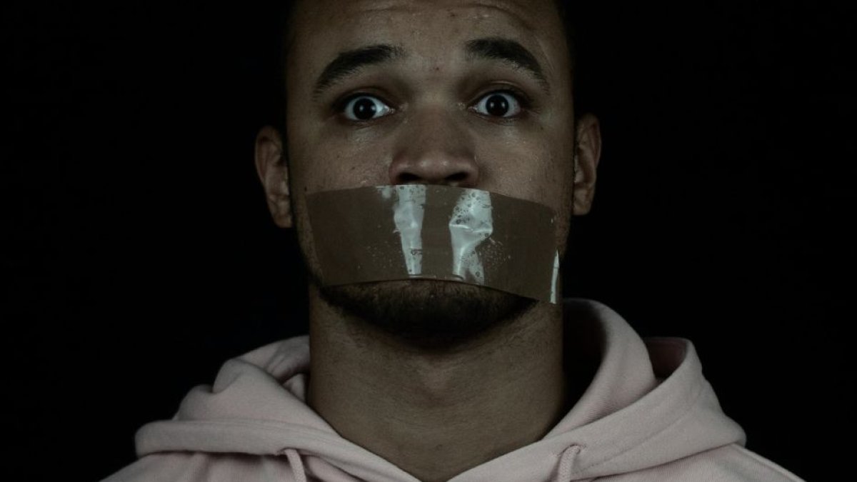 Imagen de archivo en blanco y negro de un hombre con la boca encintada.
