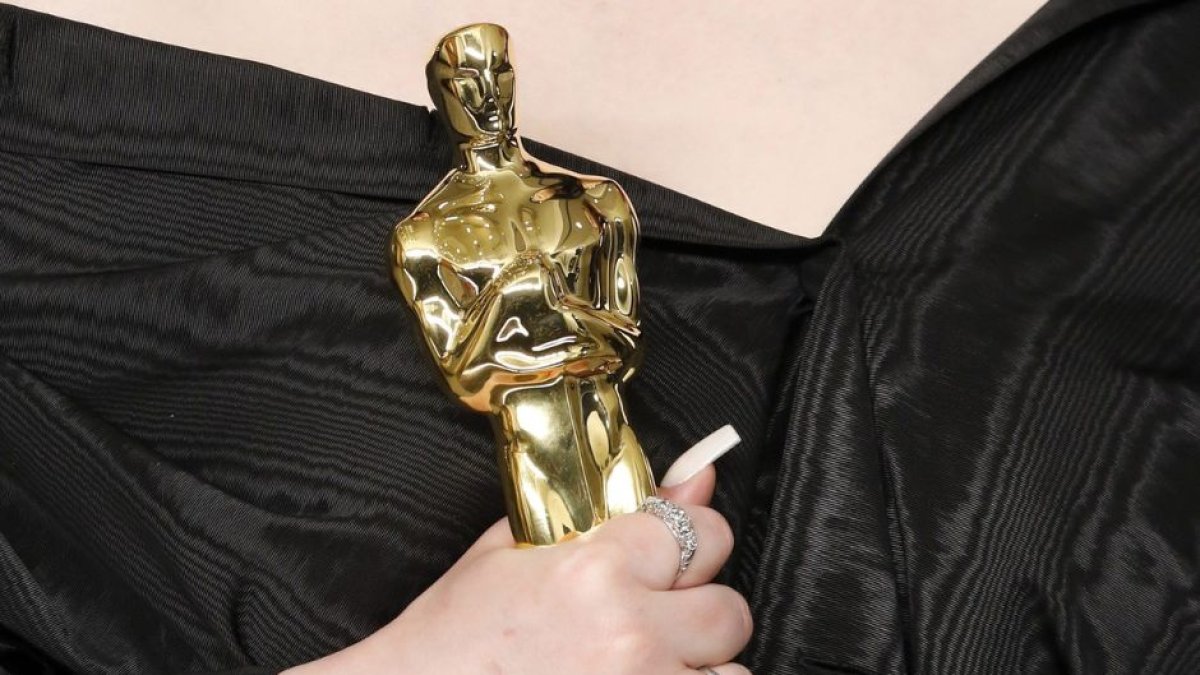 Imagen de la mano de Billie Eilish sosteniendo un premio Óscar en la ceremonia celebrada en el año 2022.