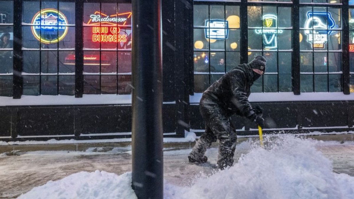 Un hombre lucha por contener las mansalvas de nieve que se hacinan en las calles de un pequeño pueblo de Iowa. Va tan solo equipado con una pala.