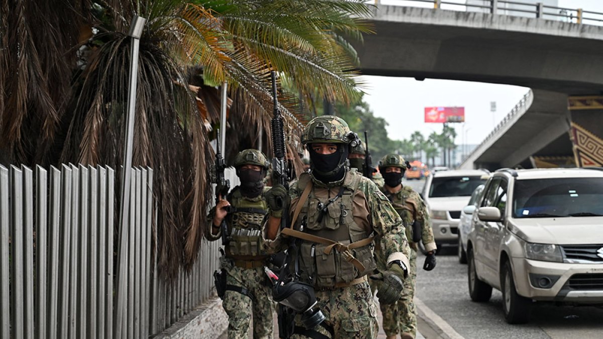Ecuadorean soldiers patrol outside the premises of Ecuador's TC television channel after unidentified gunmen burst into the state-owned television studio live on air on January 9, 2024, in Guayaquil, Ecuador, a day after Ecuadorean President Daniel Noboa declared a state of emergency following the escape from prison of a dangerous narco boss. - Gunshots rang out on live TV in violence-torn Ecuador as armed men carrying rifles and grenades stormed the studio shortly after gangsters vowed a 