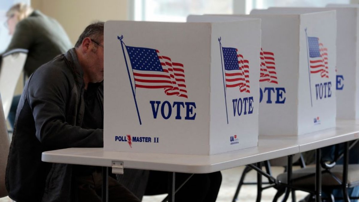 Varias personas depositan su voto en las elecciones de mitad de mandato en Wolverine Lake, Michigan, el 8 de noviembre de 2022.