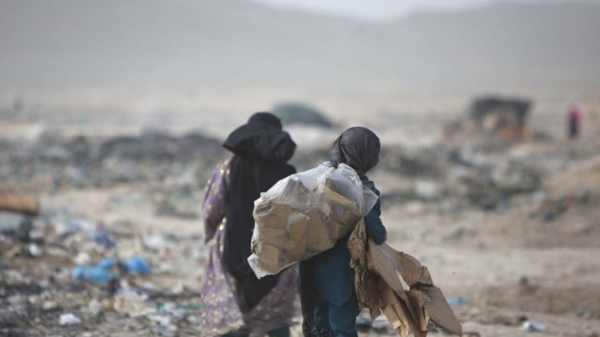 Niñas afganas llevan su bolsa, que está llena de artículos utilizables en un sitio de basura en Kabul, Afganistán, el 5 de junio de 2012, el Día Mundial del Medio Ambiente.