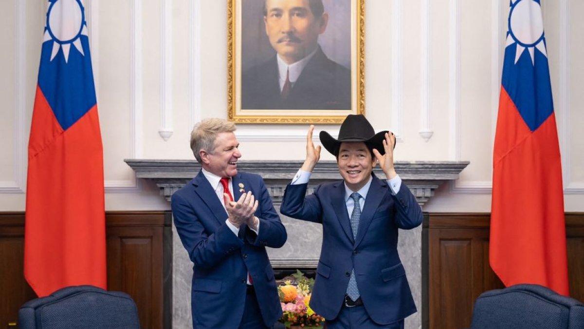 Esta foto tomada y difundida por la Oficina Presidencial de Taiwán el 27 de mayo de 2024 muestra al presidente de Taiwán, Lai Ching-te (d), poniéndose un sombrero recibido del representante estadounidense Michael McCaul (i) durante una reunión en la Oficina Presidencial en Taipei. El 27 de mayo, un alto legislador estadounidense reafirmó el apoyo de Washington a Taiwán frente a la 