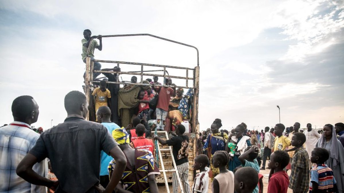 Personas que huyen de la guerra sudanesa desembarcan de un camión que las ha traído a Renk desde el paso fronterizo de Joda, en Sudán del Sur.